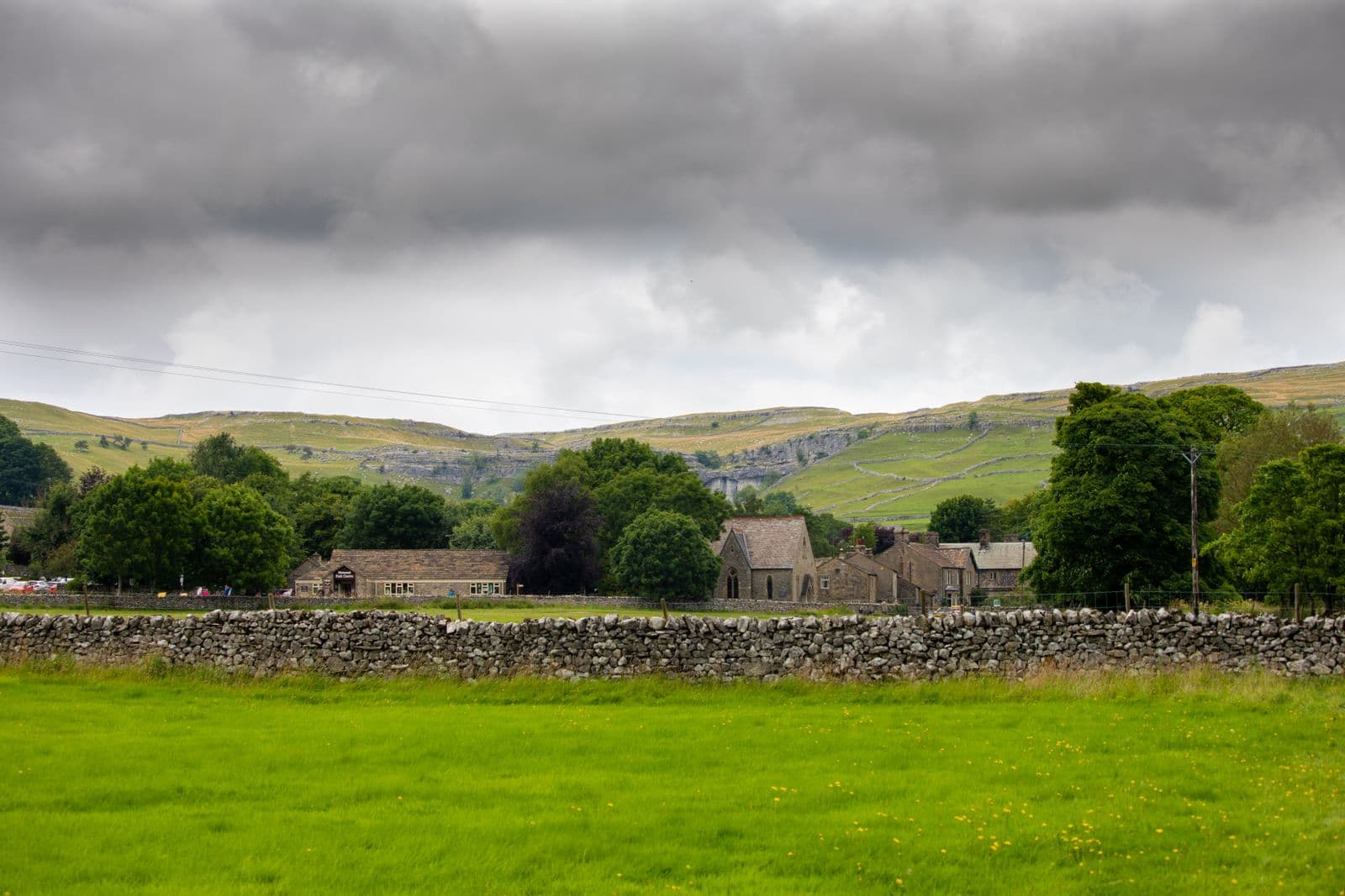 Yorkshire stone village with dry stone walls and green hills