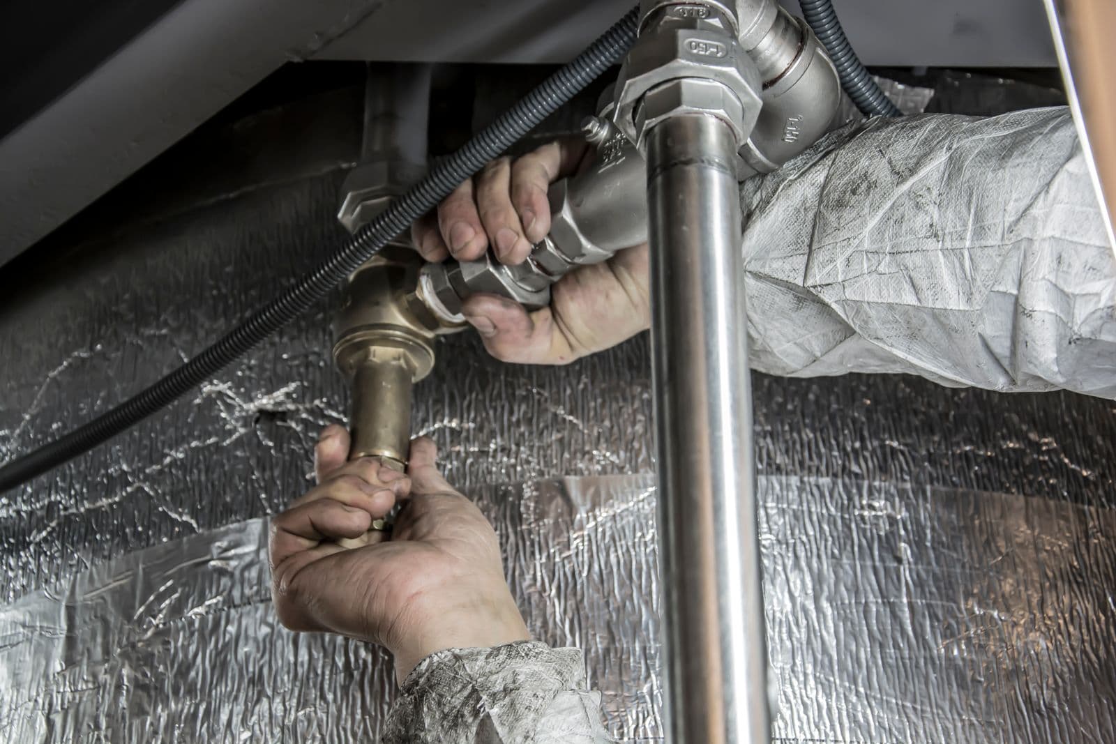 Engineer working on plumbing pipework