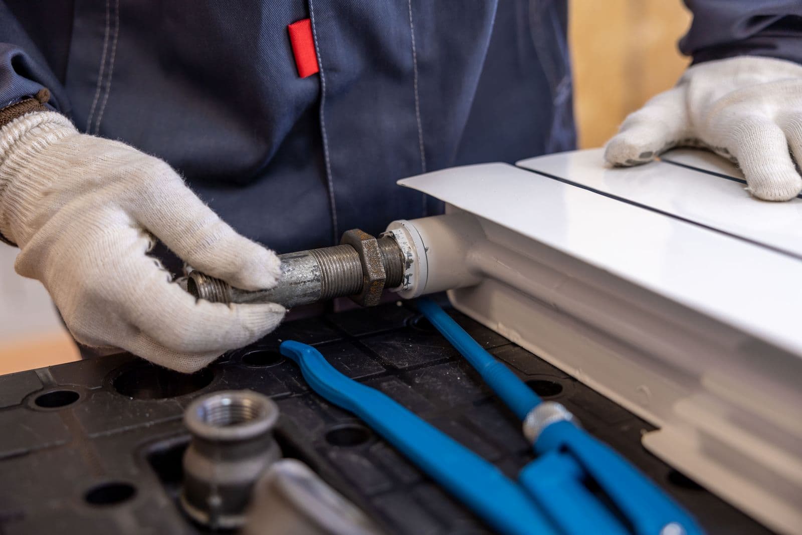 Engineer installing a radiator pipe